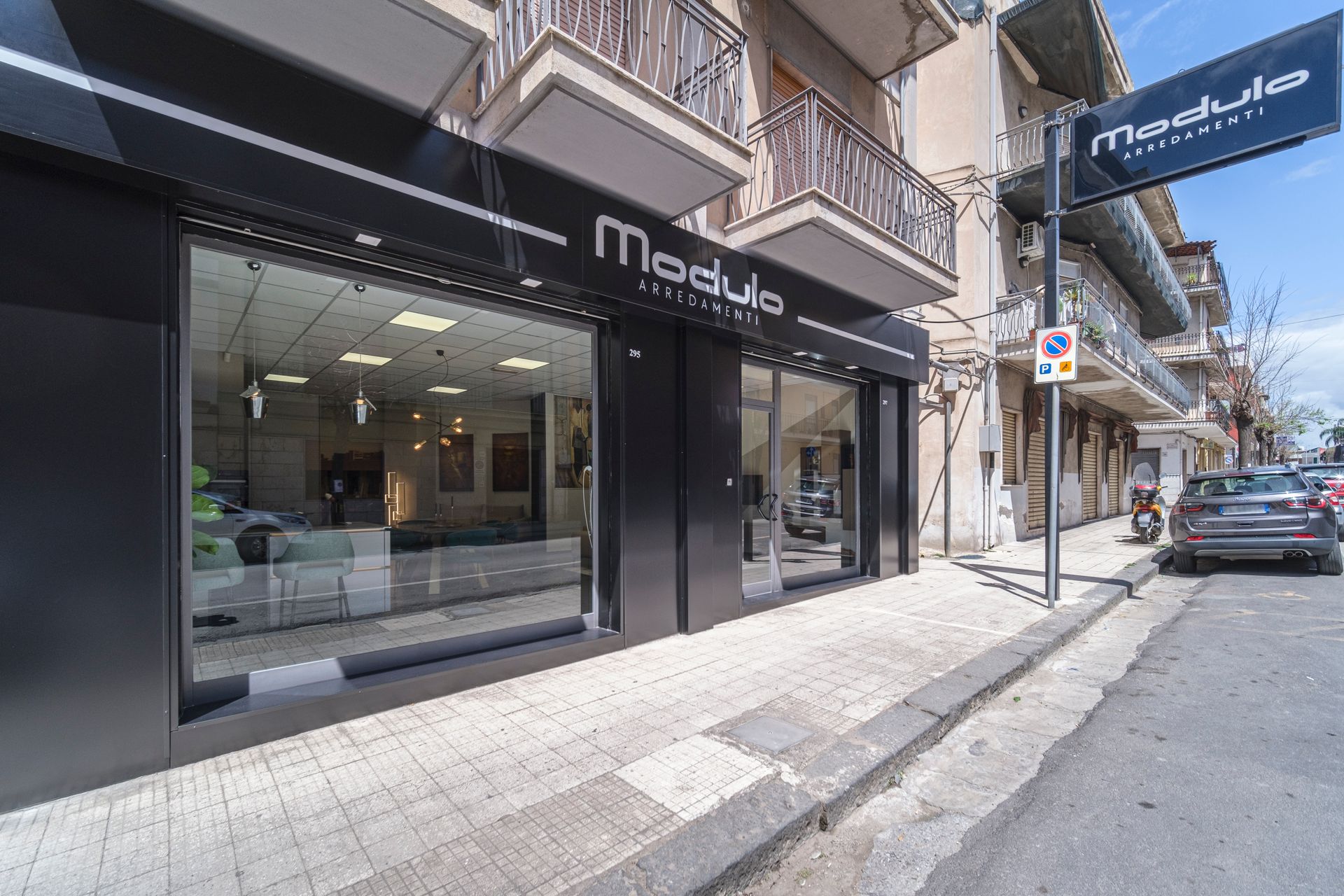 Una vetrina con un'auto parcheggiata davanti.