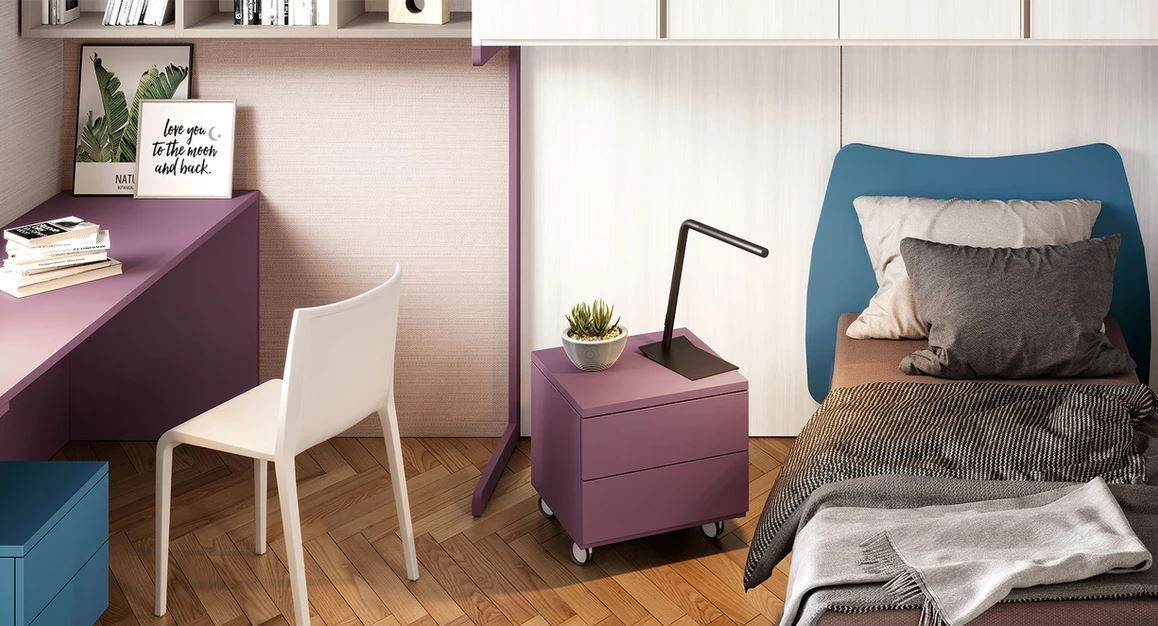 Una camera da letto con un letto, una scrivania, una sedia e un comodino.