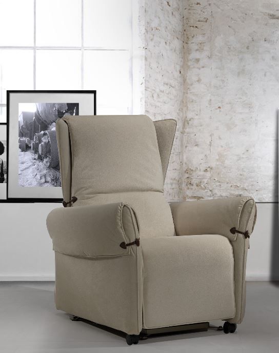 Una poltrona reclinabile beige è posizionata in un soggiorno accanto a una finestra.