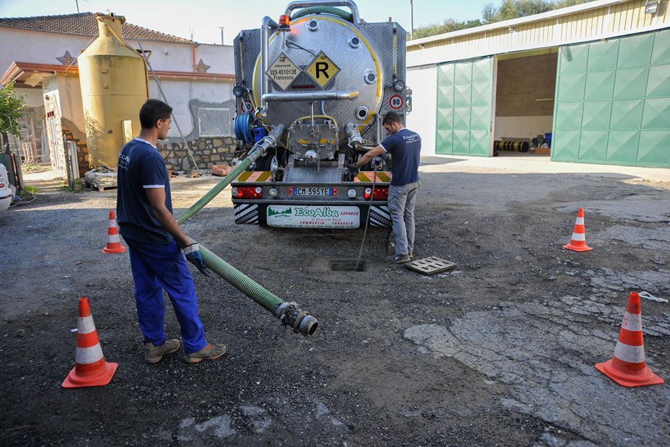 addetti dell'impresa durante lo spurgo di una fognatura