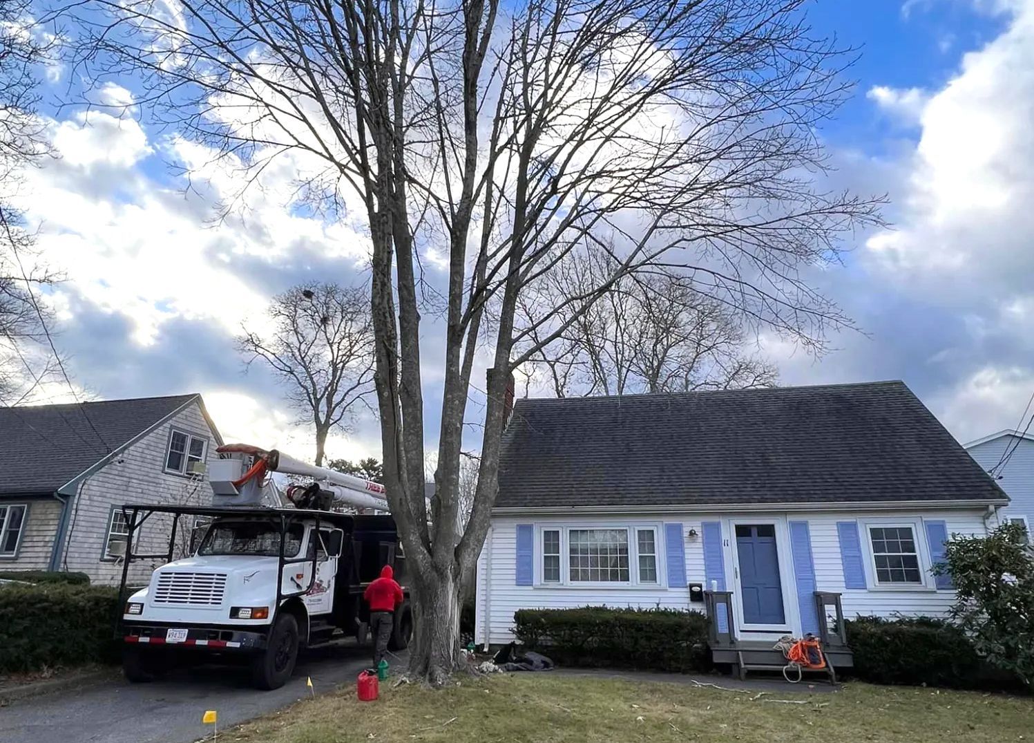 a tree cutting truck is parked in front of a house .