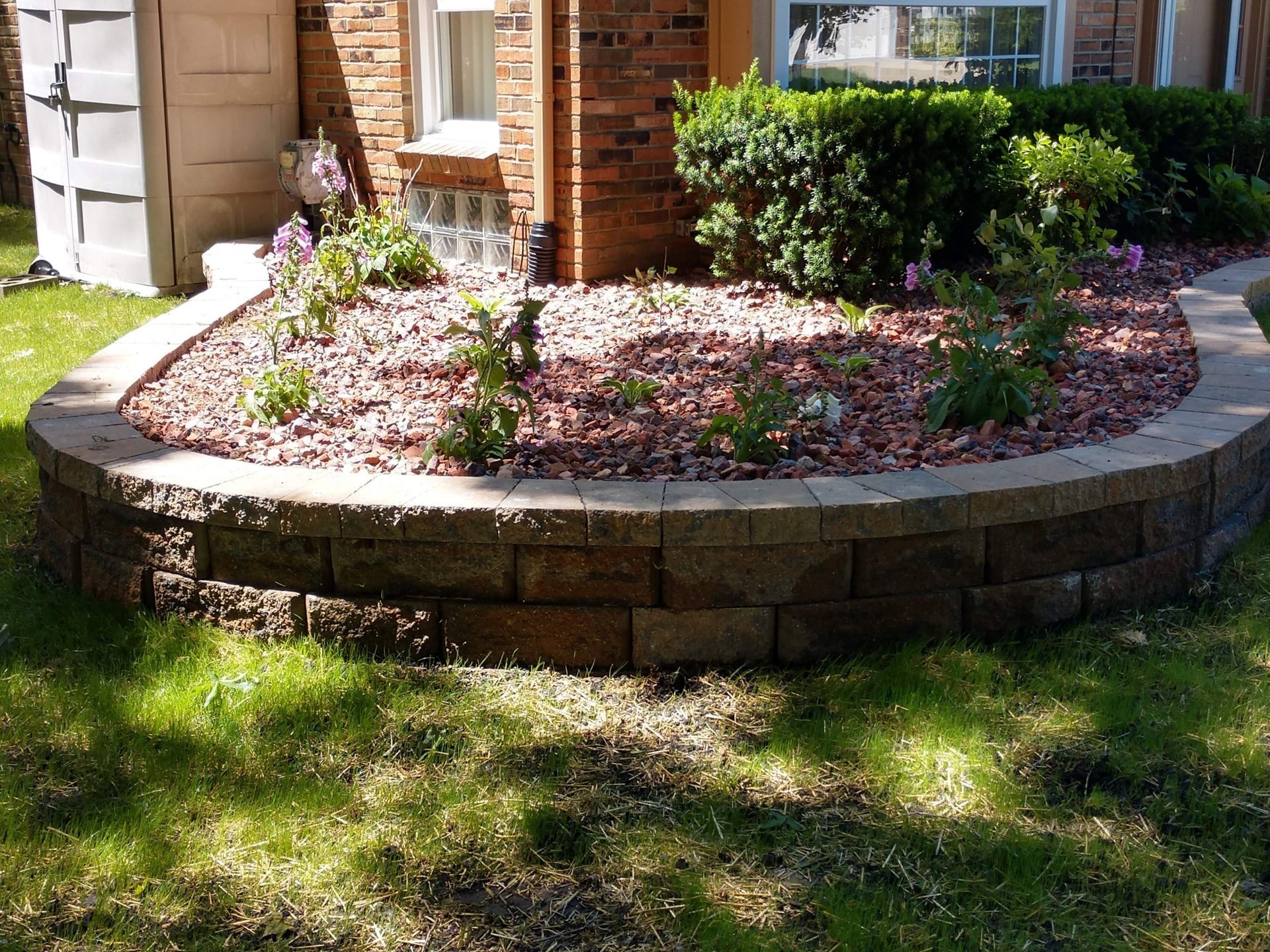 Garden with retainer wall made of grey bricks 