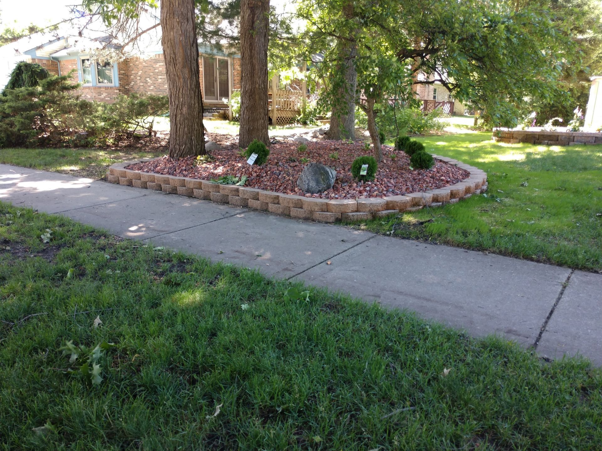 Red brick retainer wall around red wood chip bed
