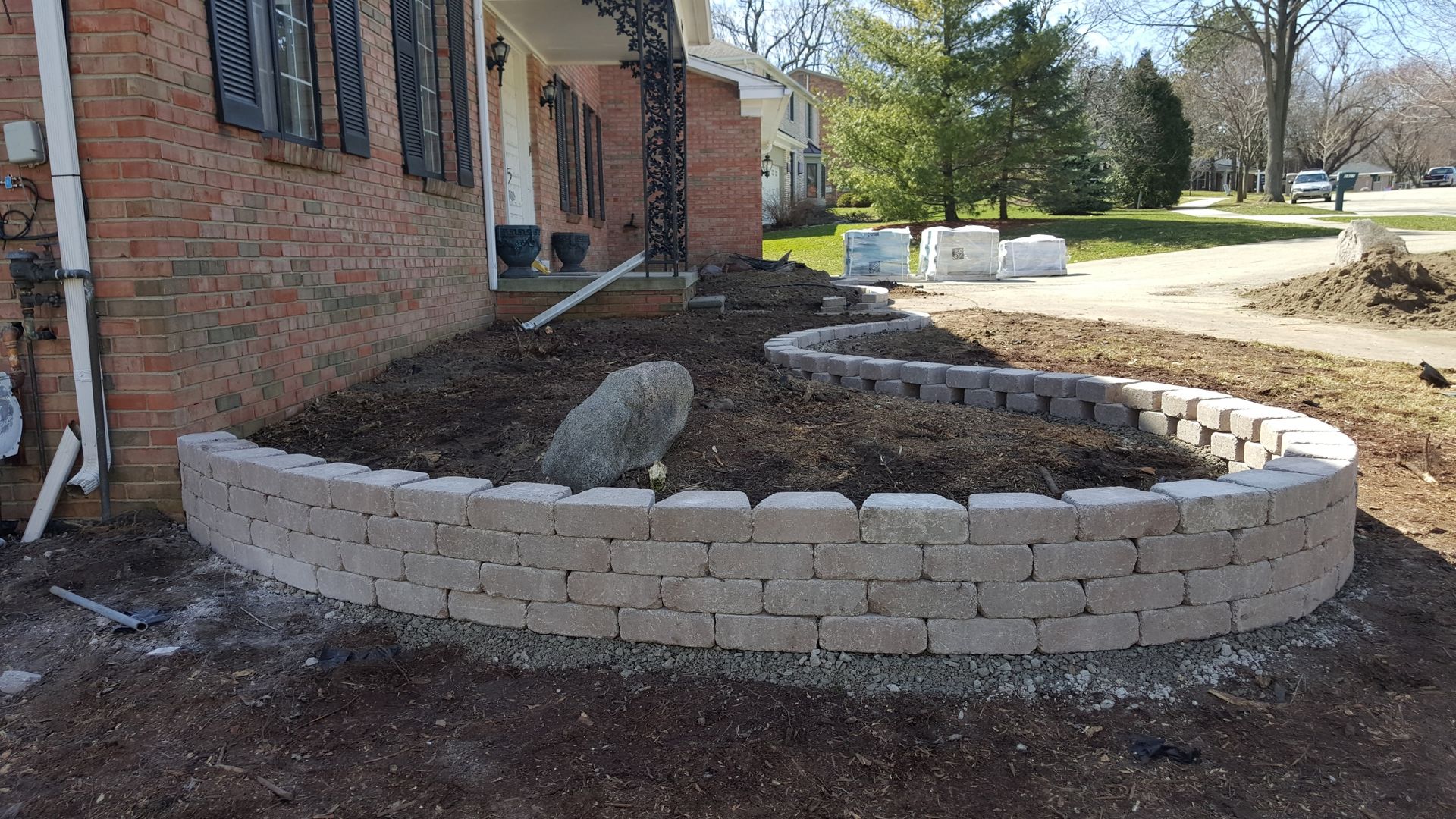 Garden with retainer wall made of grey bricks 
