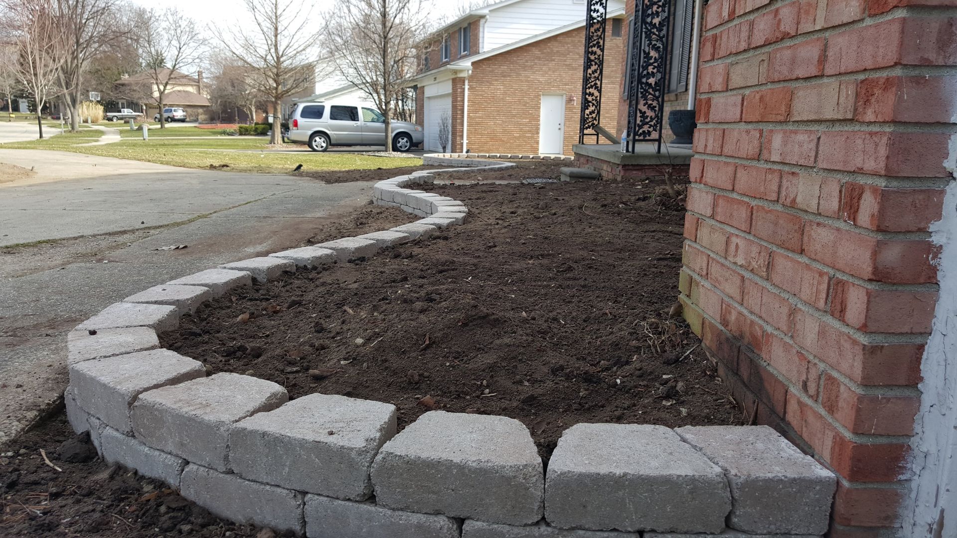 Garden with retainer wall made of grey bricks 