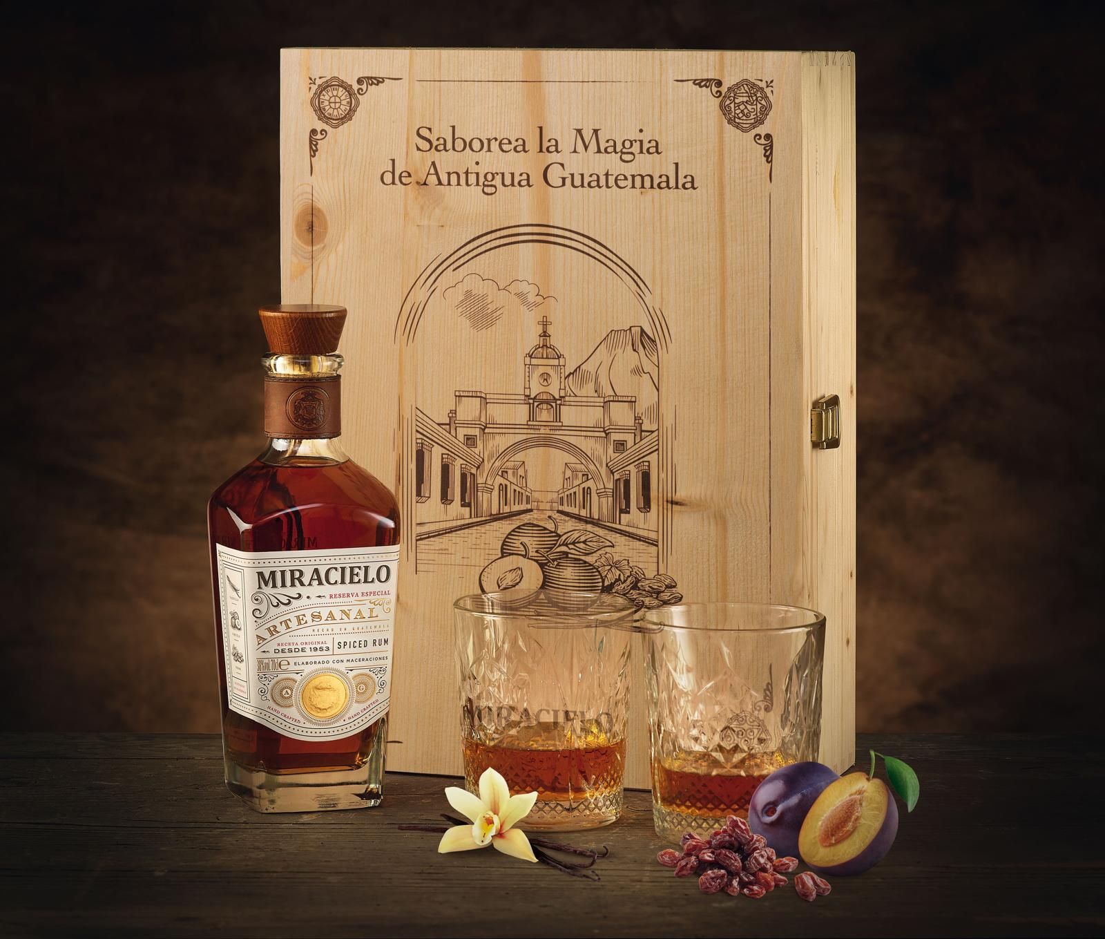 Bottiglia di rum Miracielo, due bicchieri, scatola di legno con illustrazione, prugne, vaniglia.