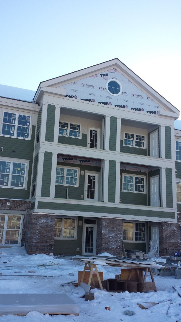 A large building with a lot of windows is being built in the snow.