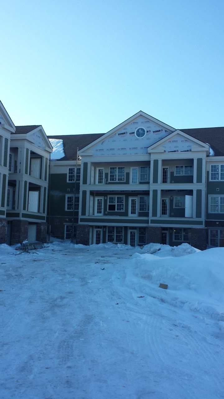 A large building with a lot of windows is covered in snow.