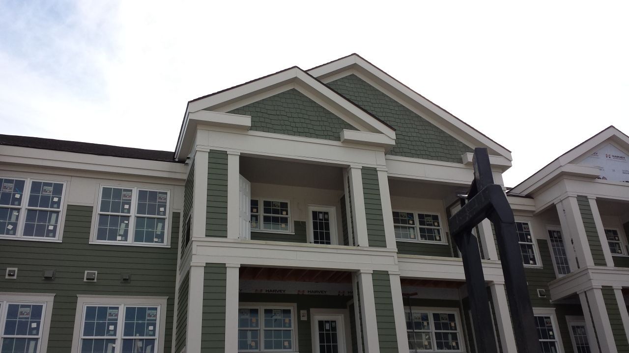 A large green and white building with a sign in front of it