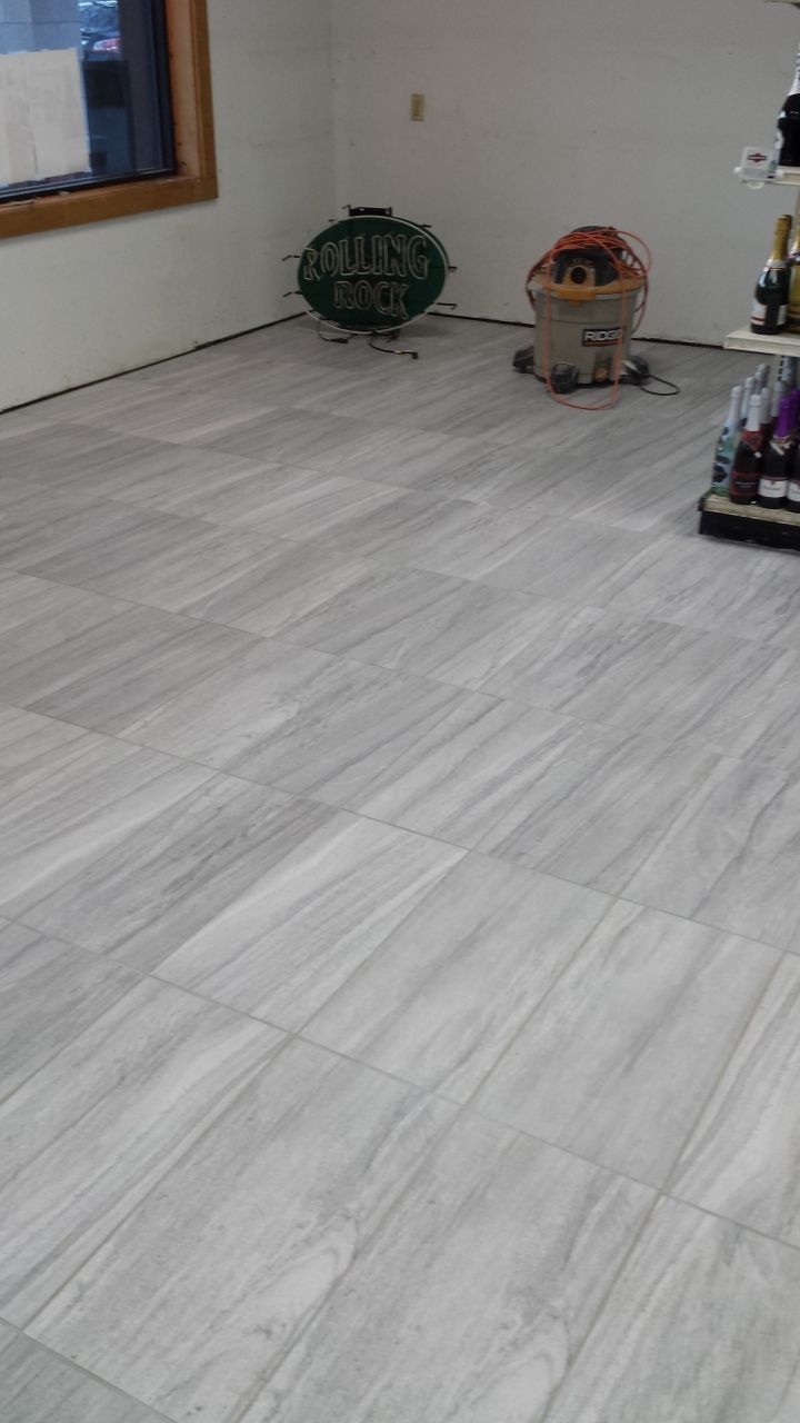 A room with a tiled floor and a vacuum cleaner in it.