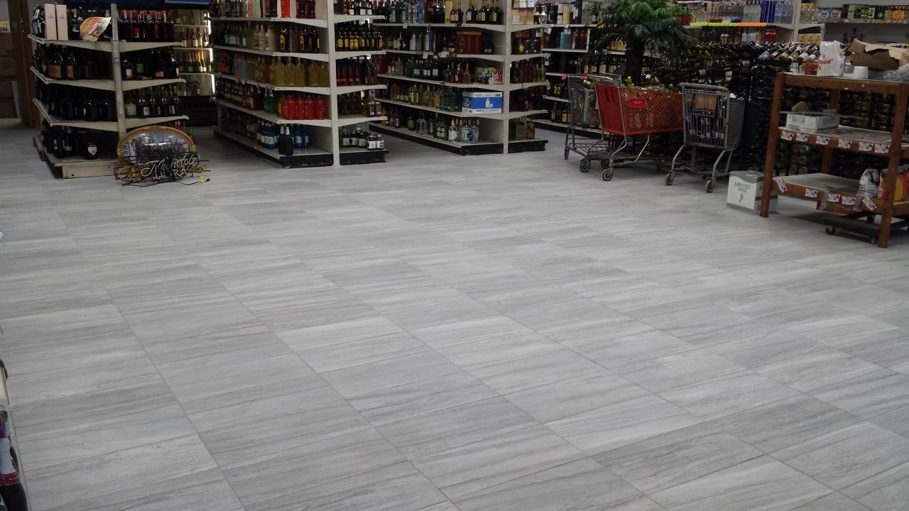 A grocery store with lots of shelves and a shopping cart.