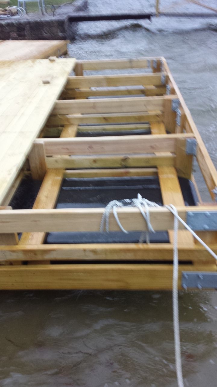 A wooden structure is floating on top of a body of water.