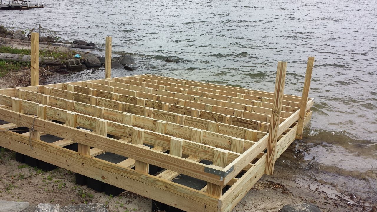 A wooden dock is being built on the shore of a lake.