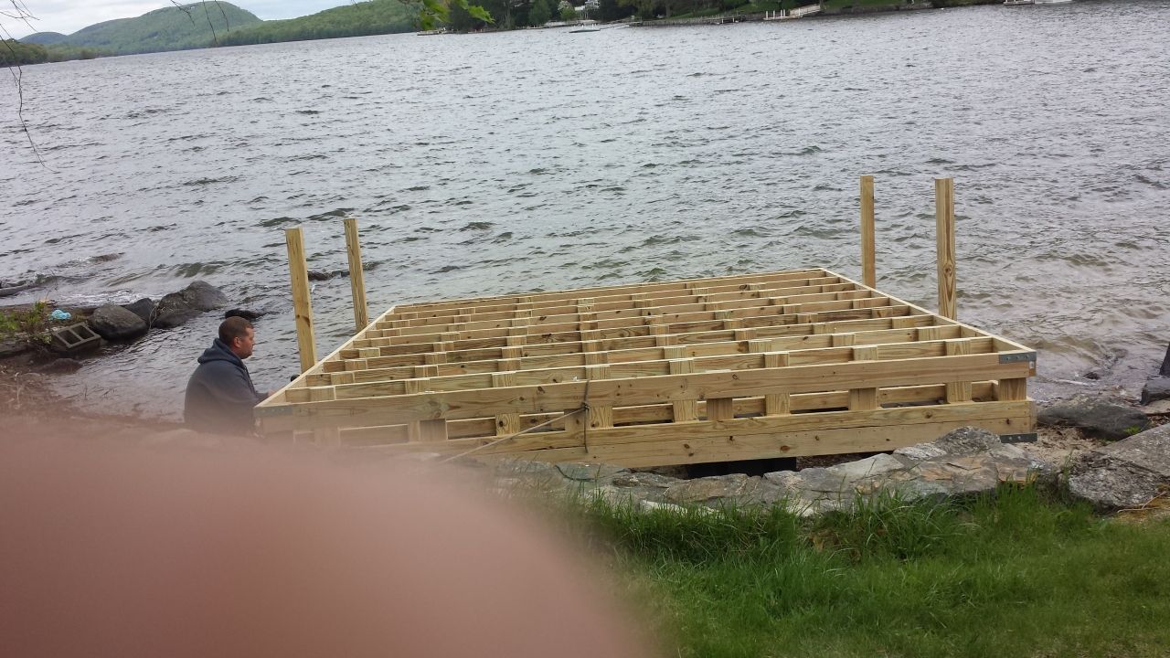 A wooden dock is being built next to a lake.