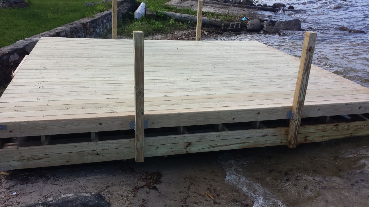 A wooden dock is sitting on the shore of a body of water.