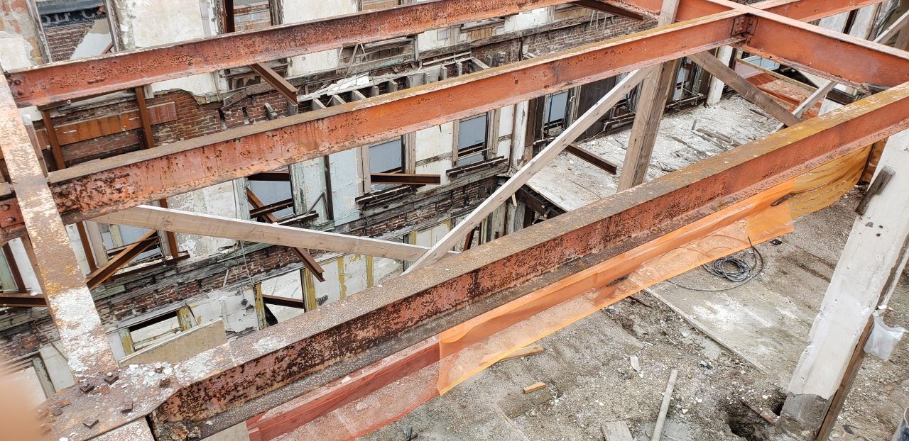 A rusty metal structure is being built in a building.
