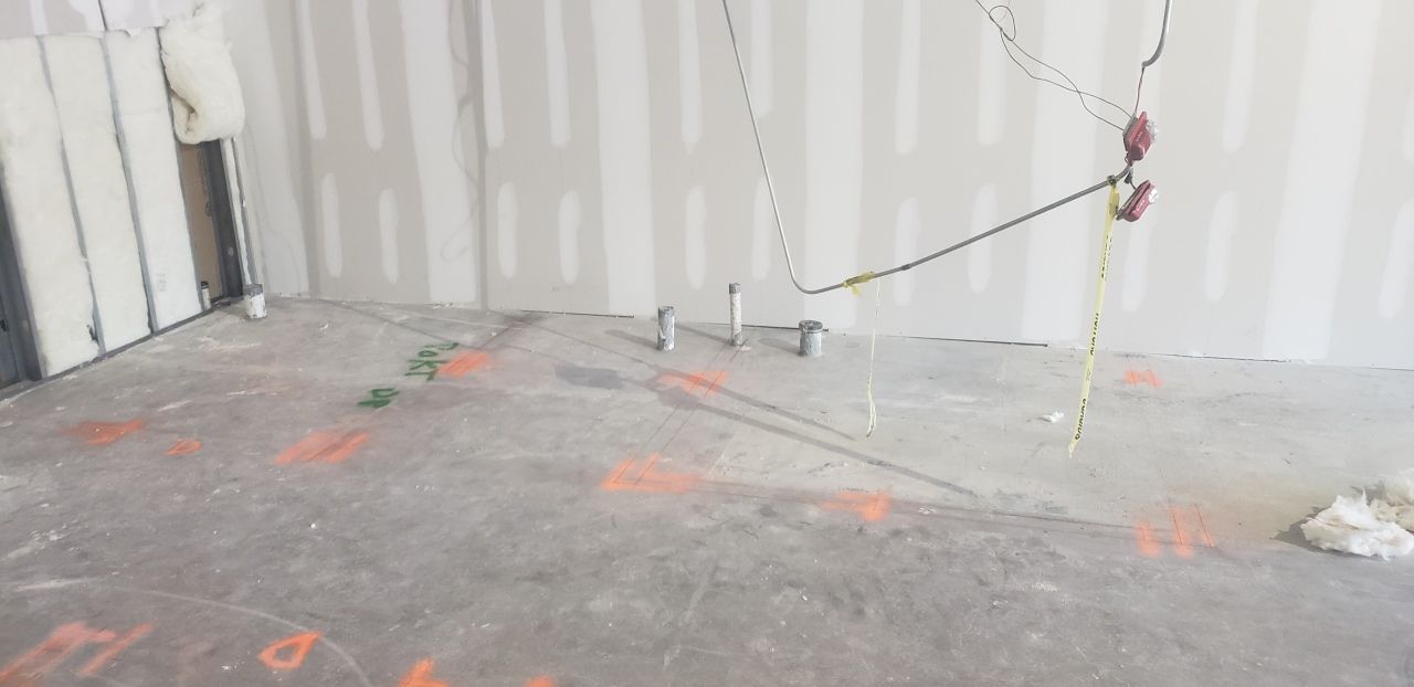 An empty room with a measuring tape on the floor.