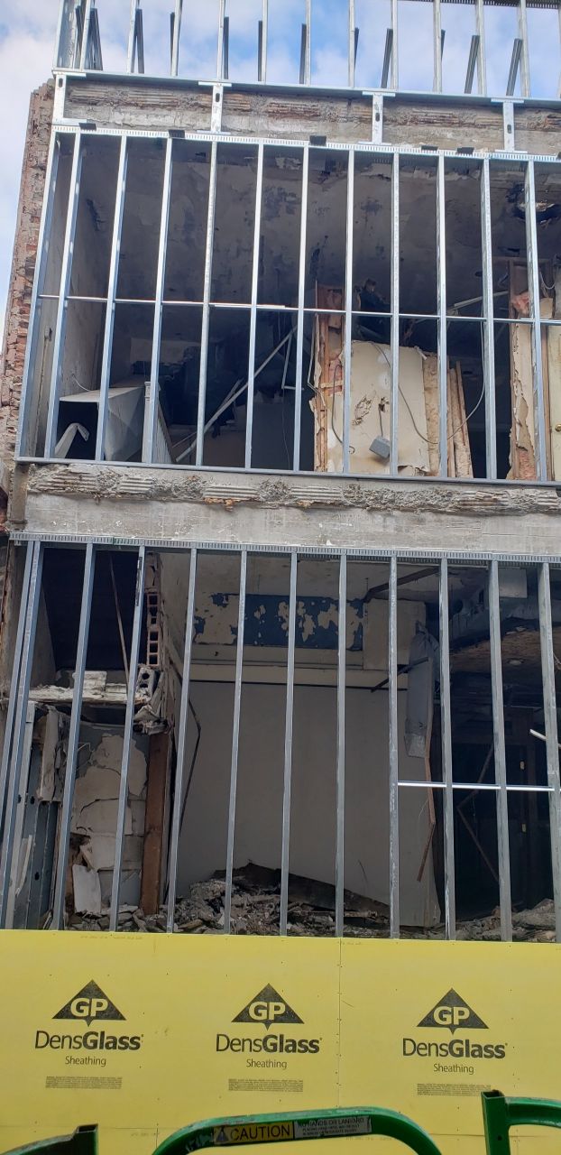 A building under construction with a yellow barrier in front of it.