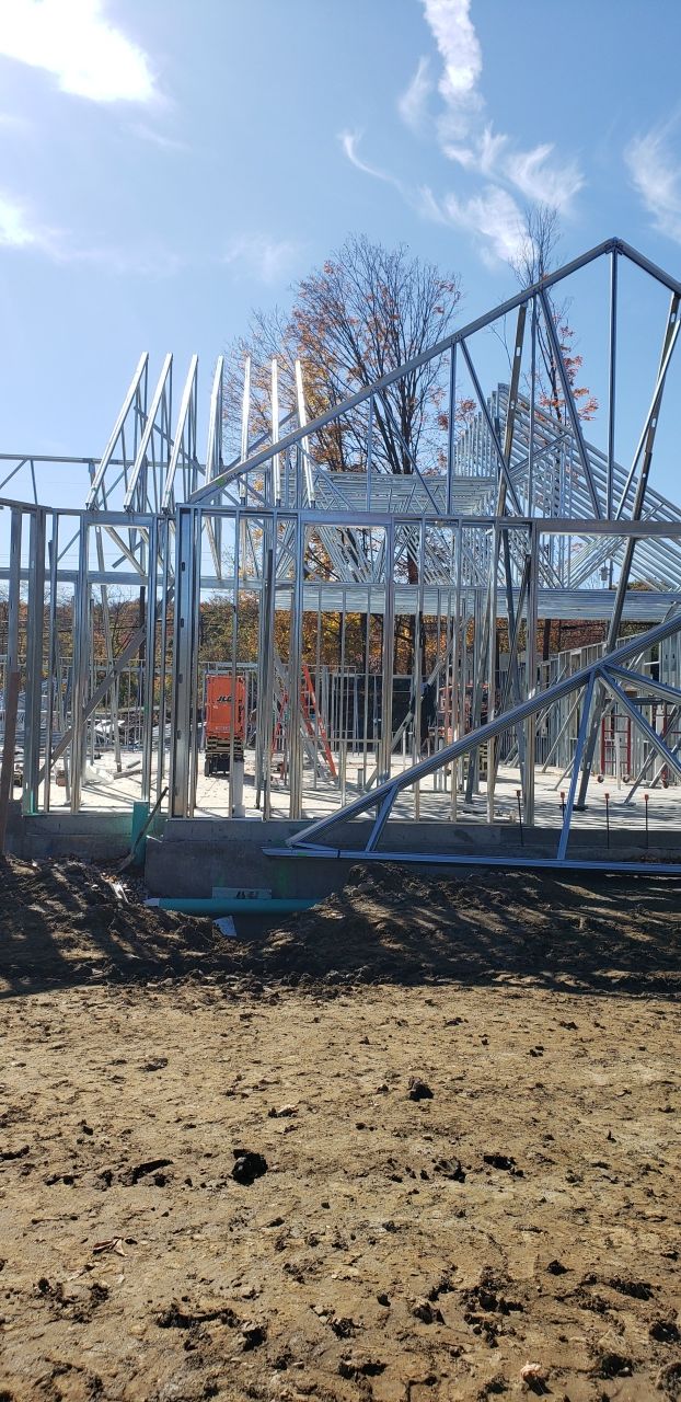 A roller coaster is being built in the middle of a dirt field.