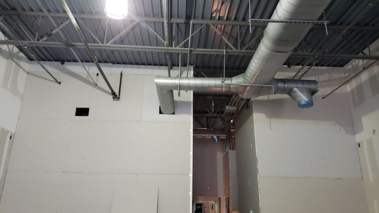 A room with a lot of pipes hanging from the ceiling.