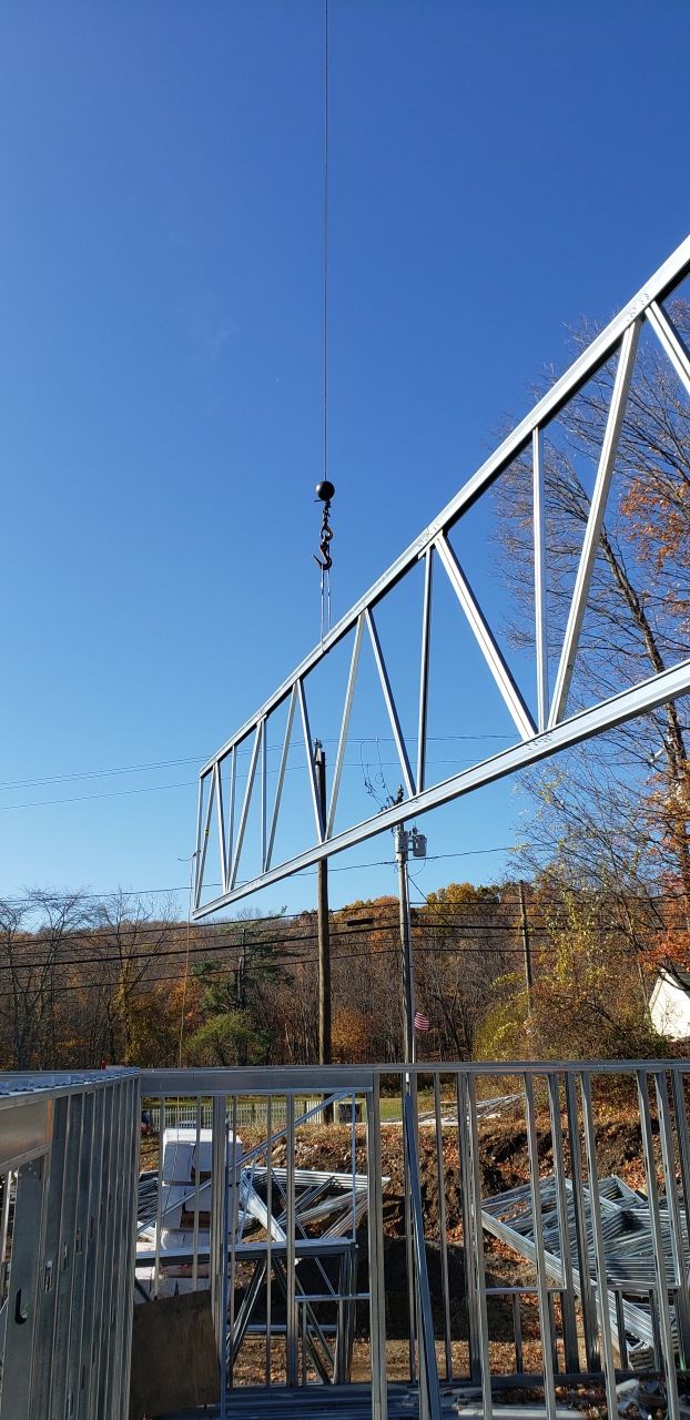 A crane is lifting a metal structure in the air.