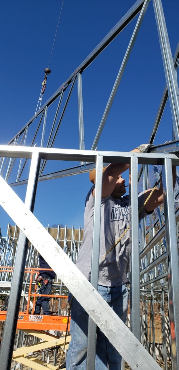 A man is working on a metal structure at a construction site.