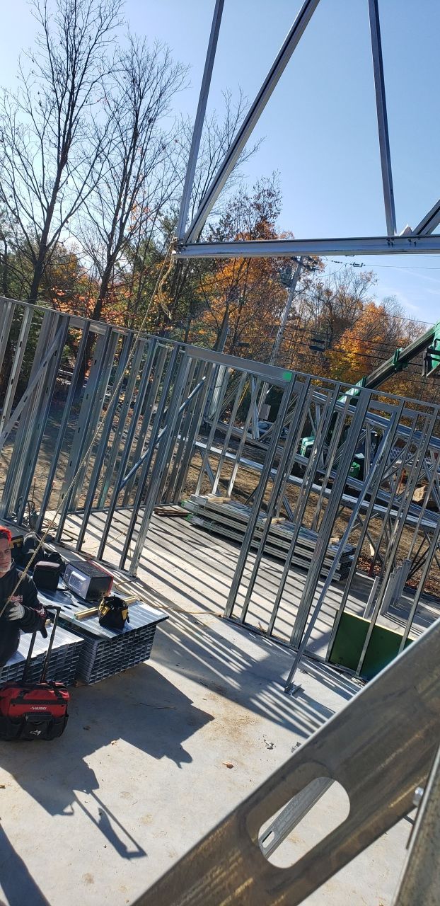 A large metal structure is being built on a sunny day.