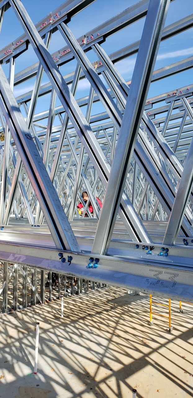 A large metal structure is being built on a construction site.