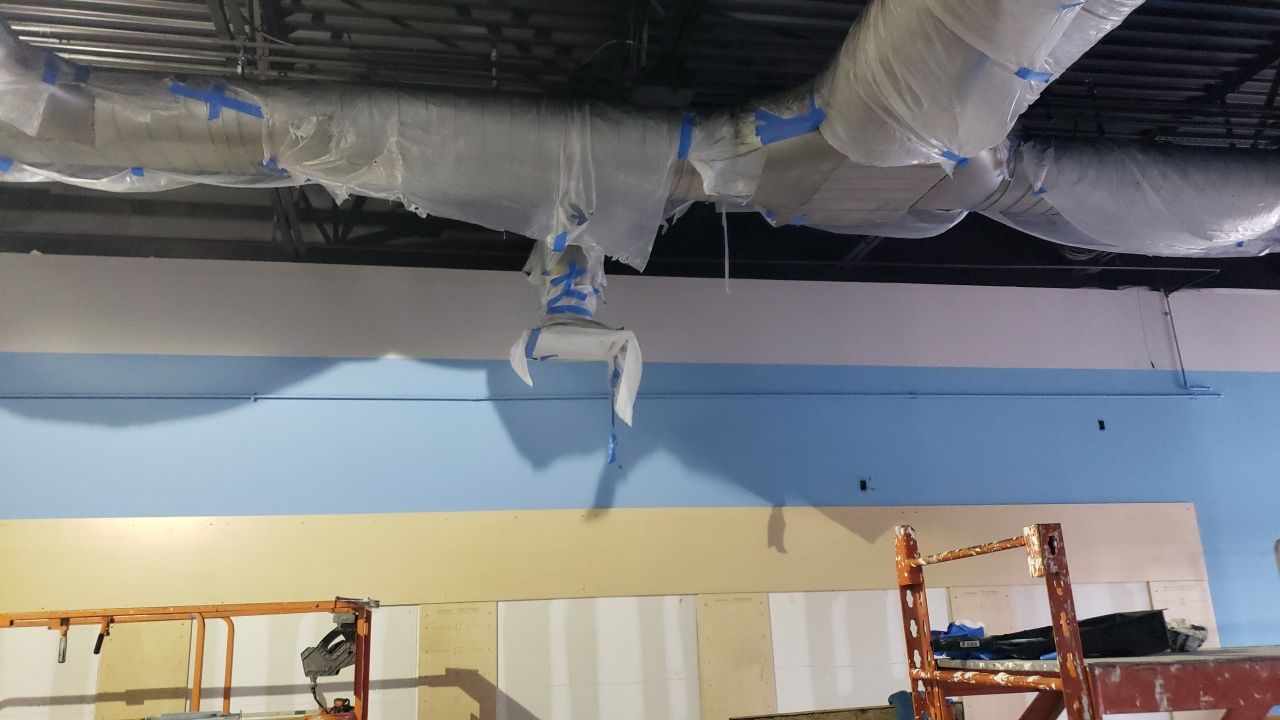 A large pipe is hanging from the ceiling of a building.