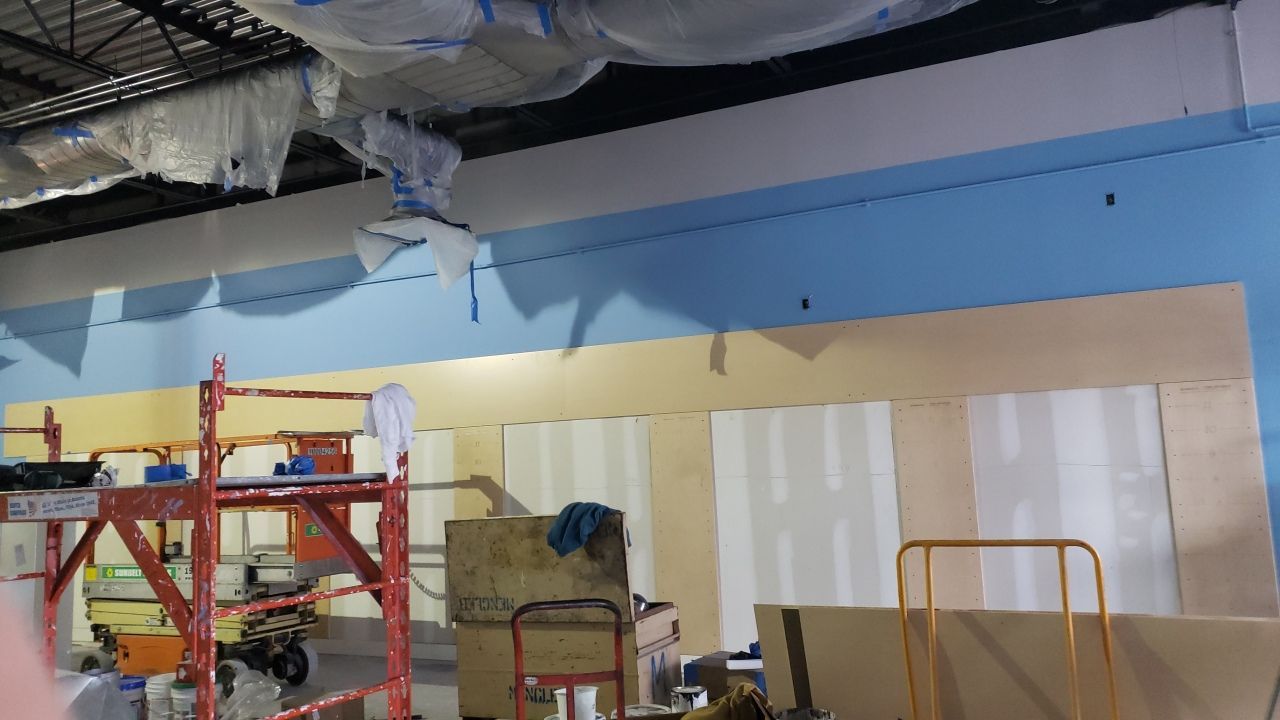 A room with a ceiling that is being painted blue and yellow.