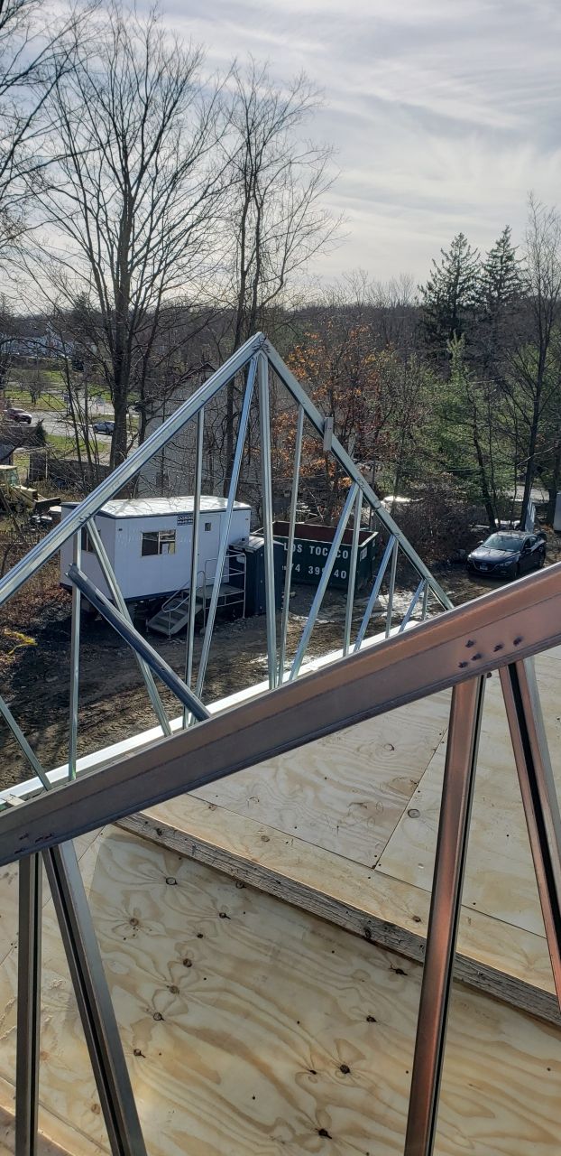 A metal structure is being built on top of a wooden deck.