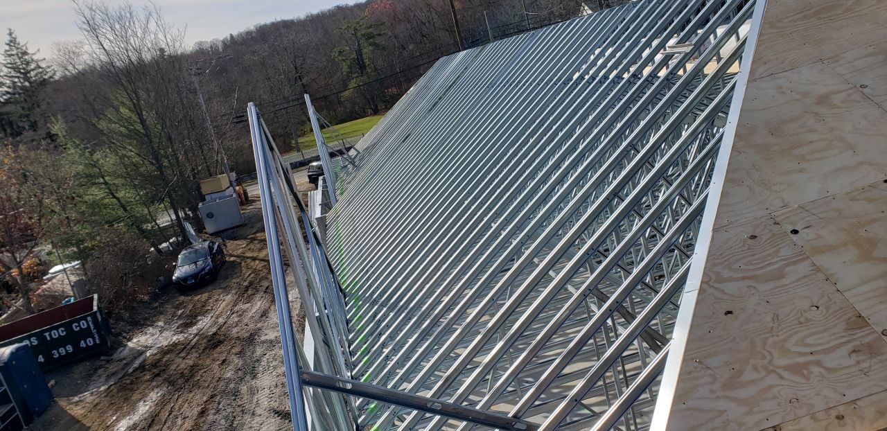 A large metal structure is being built on top of a hill.