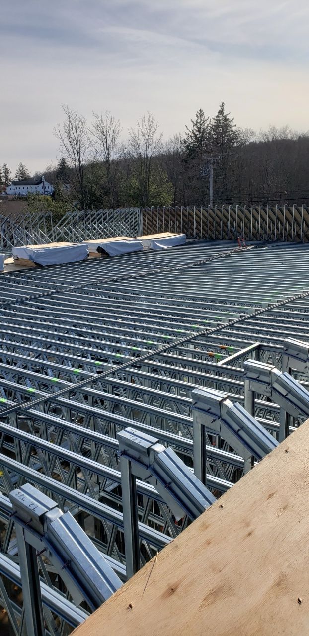 A large metal structure is being built on top of a wooden deck.