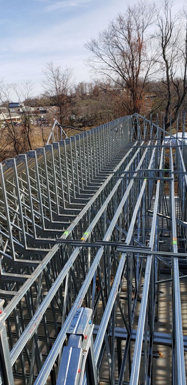 A close up of a metal structure with trees in the background.
