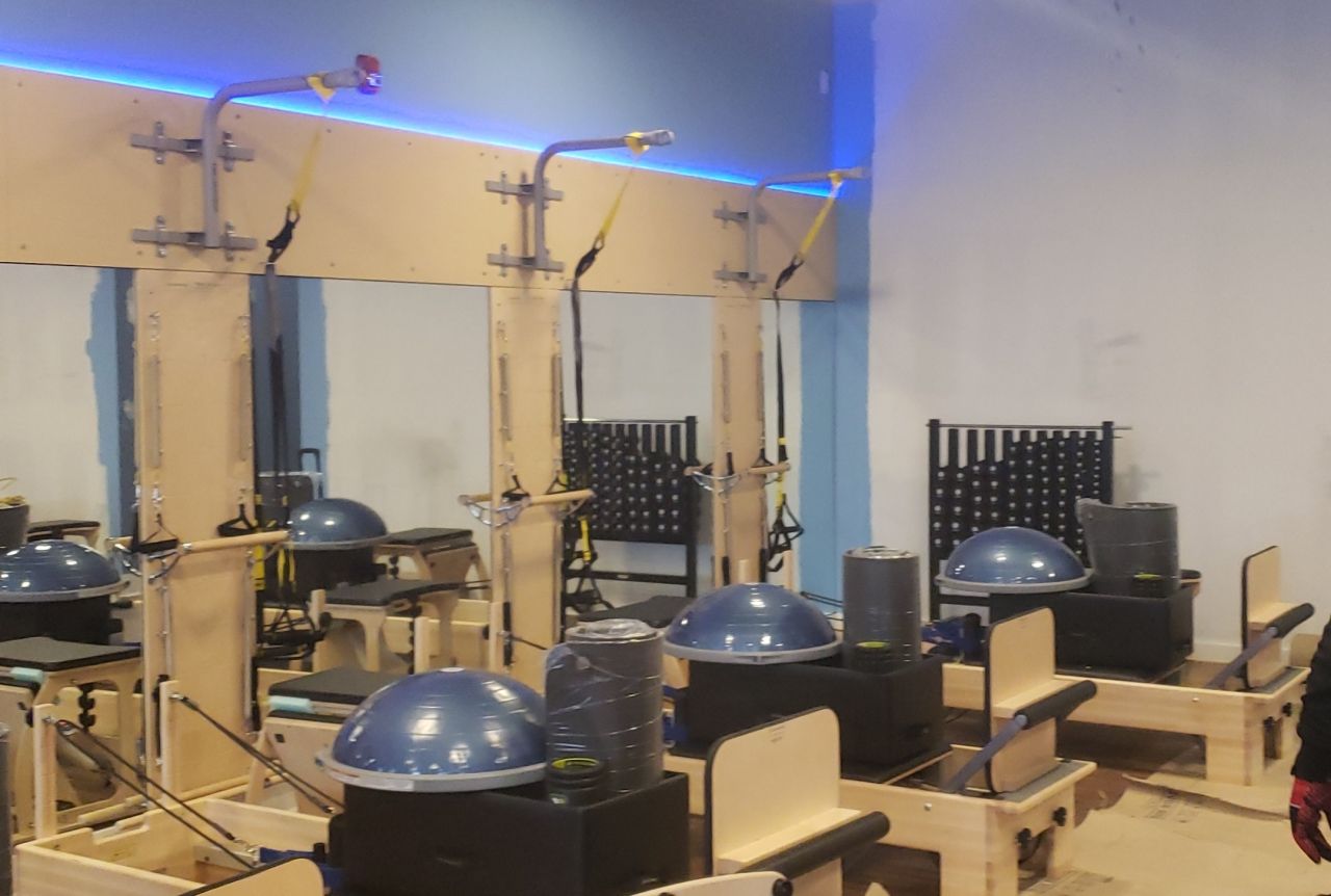 A gym with a lot of equipment and a blue light on the ceiling