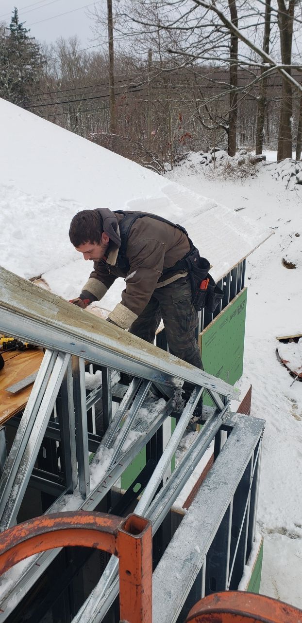 A man is working on a roof in the snow.
