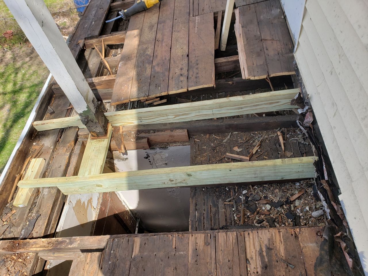 A wooden deck is being built on the side of a house.