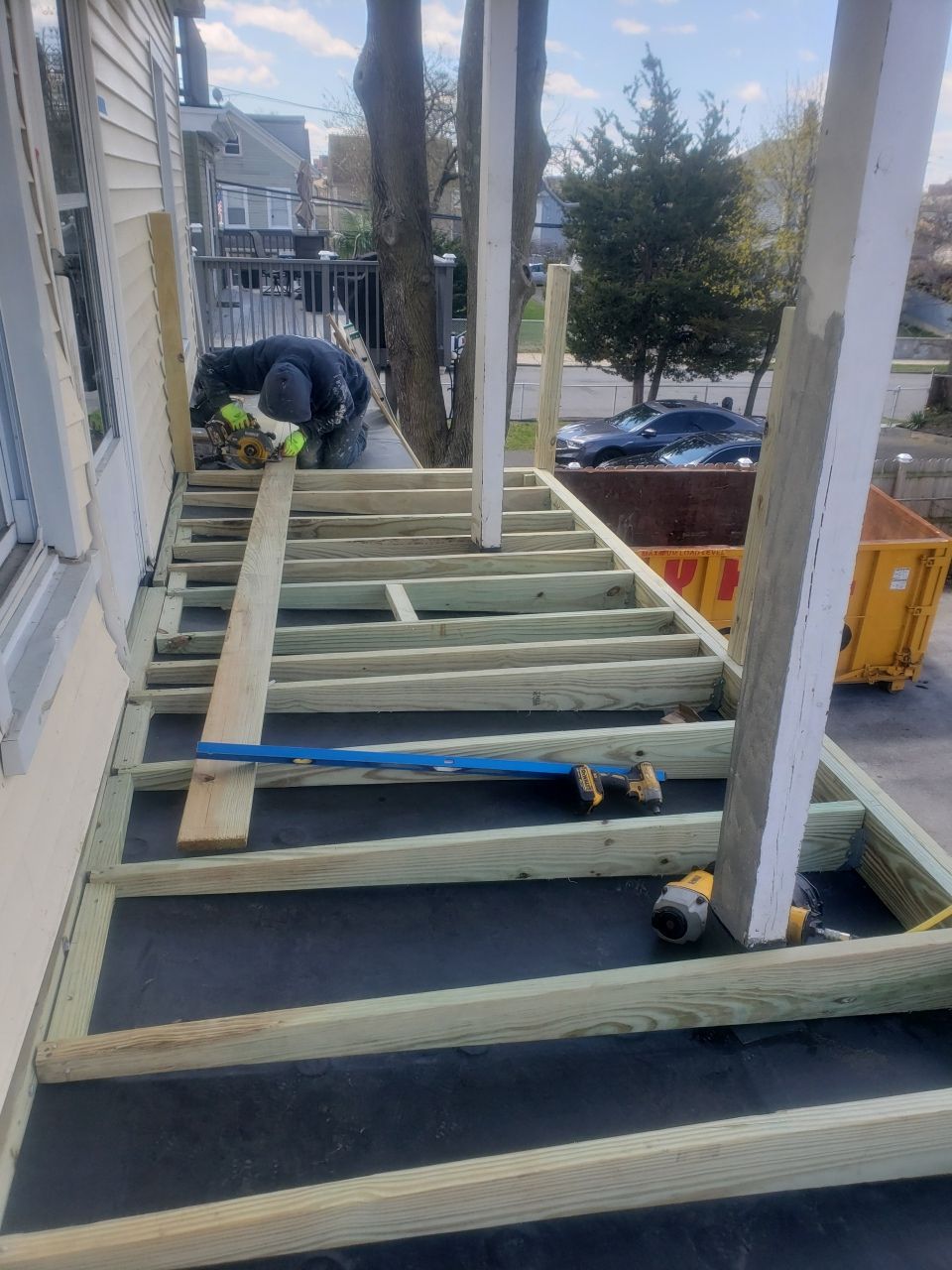A wooden deck is being built on the side of a house.