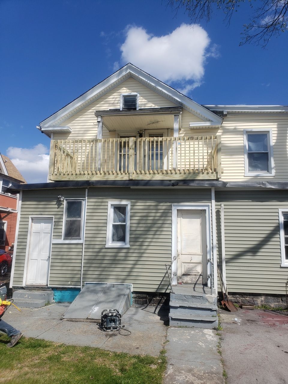 The front of a house with a balcony and stairs.