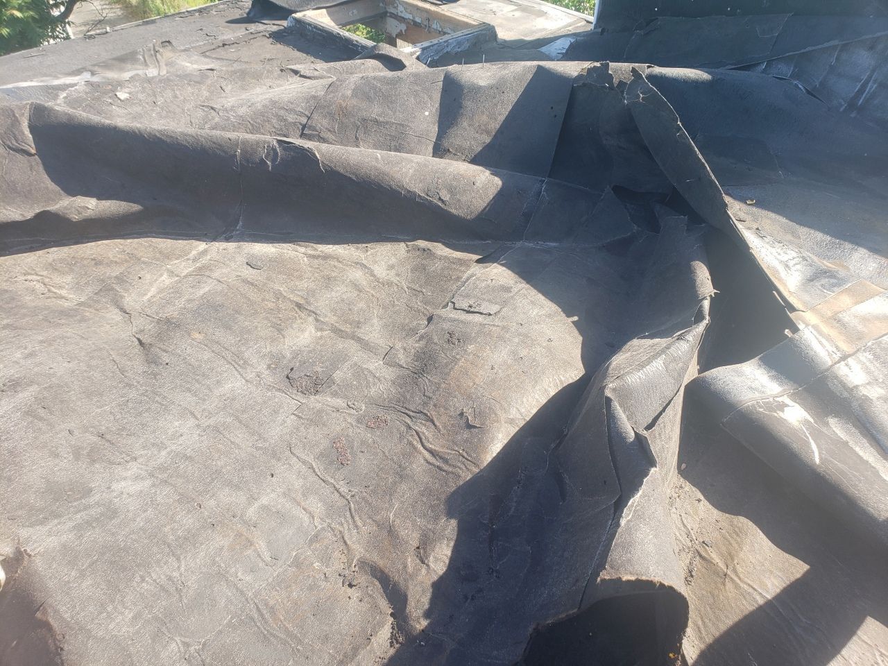 A close up of a piece of roofing material on a roof.