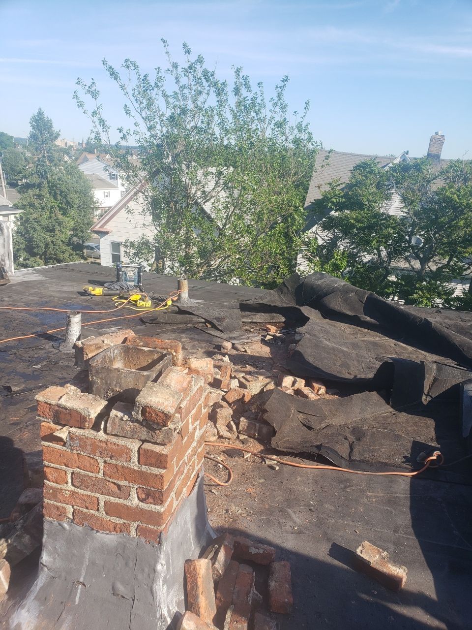 A brick chimney is sitting on top of a roof.