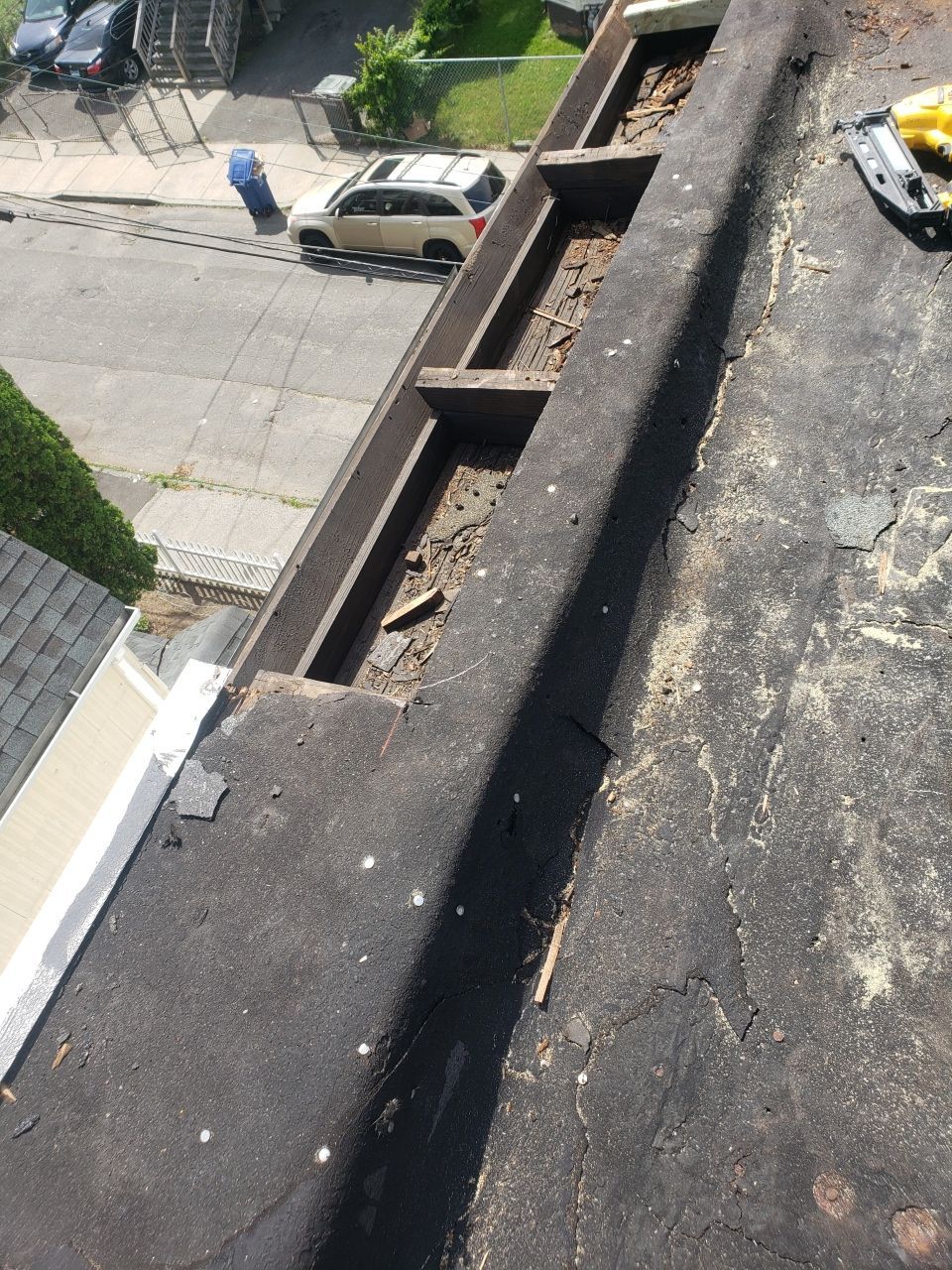 A car is parked on the side of the road next to a gutter.