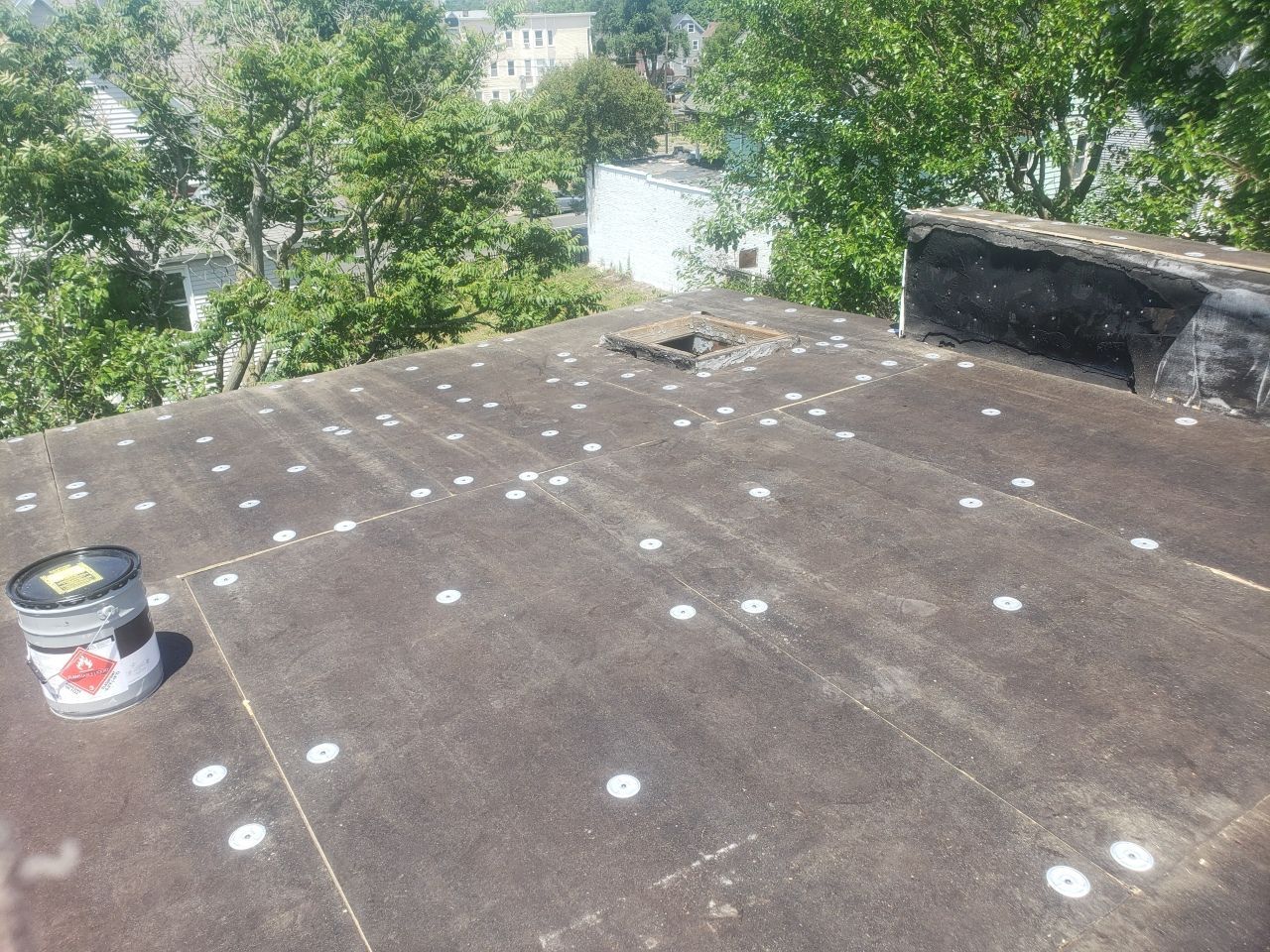 A roof with a bucket of paint on it