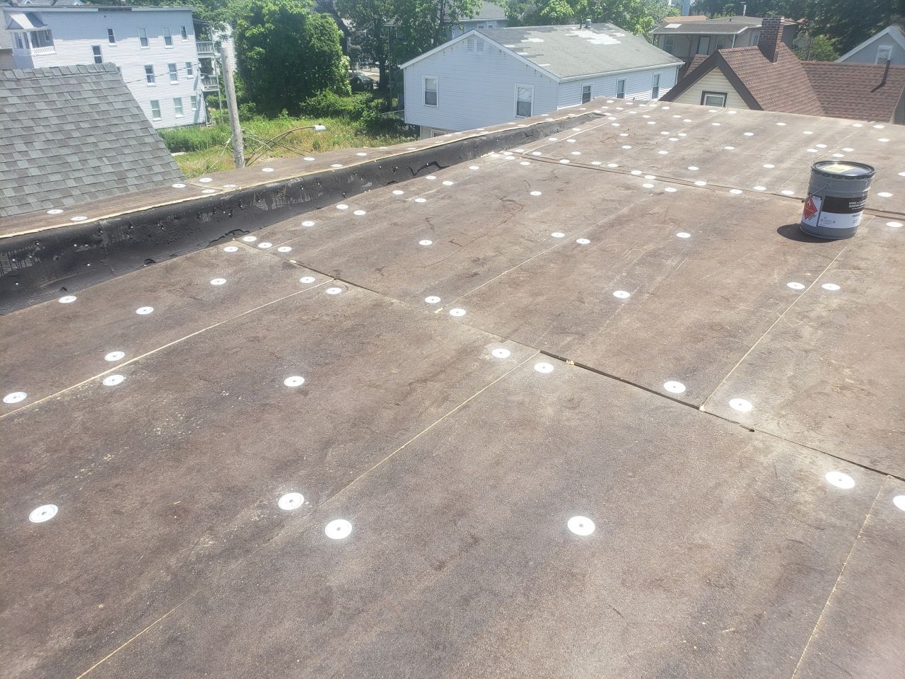 A roof with white circles on it and a bucket on it