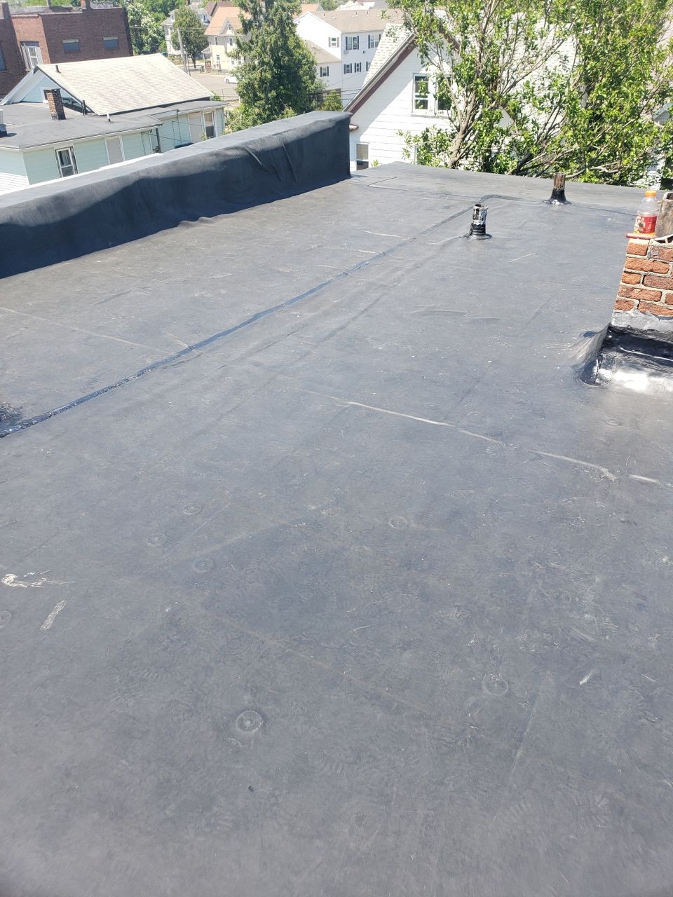 A black roof with a chimney on top of it.