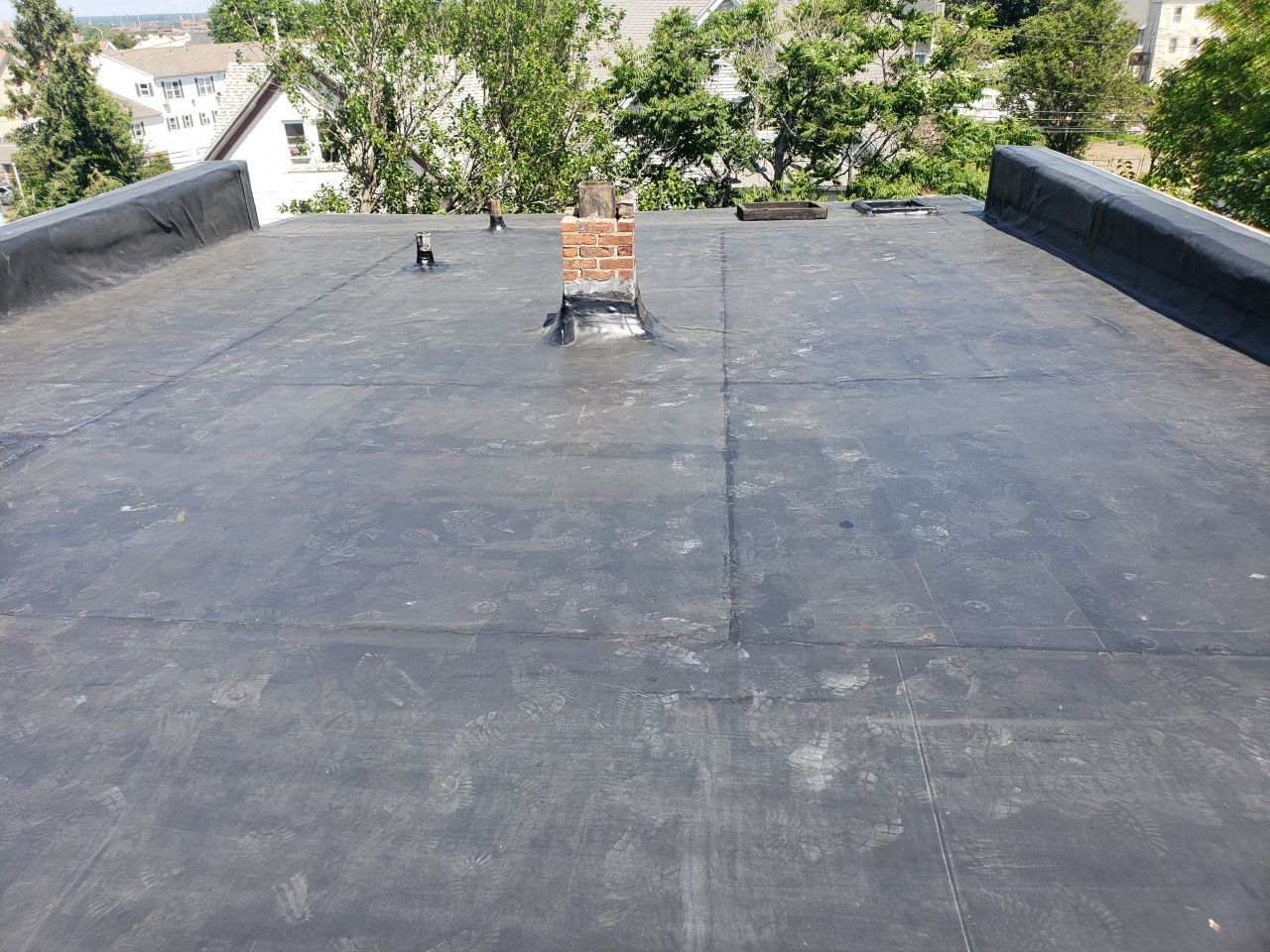 A black roof with a chimney on top of it