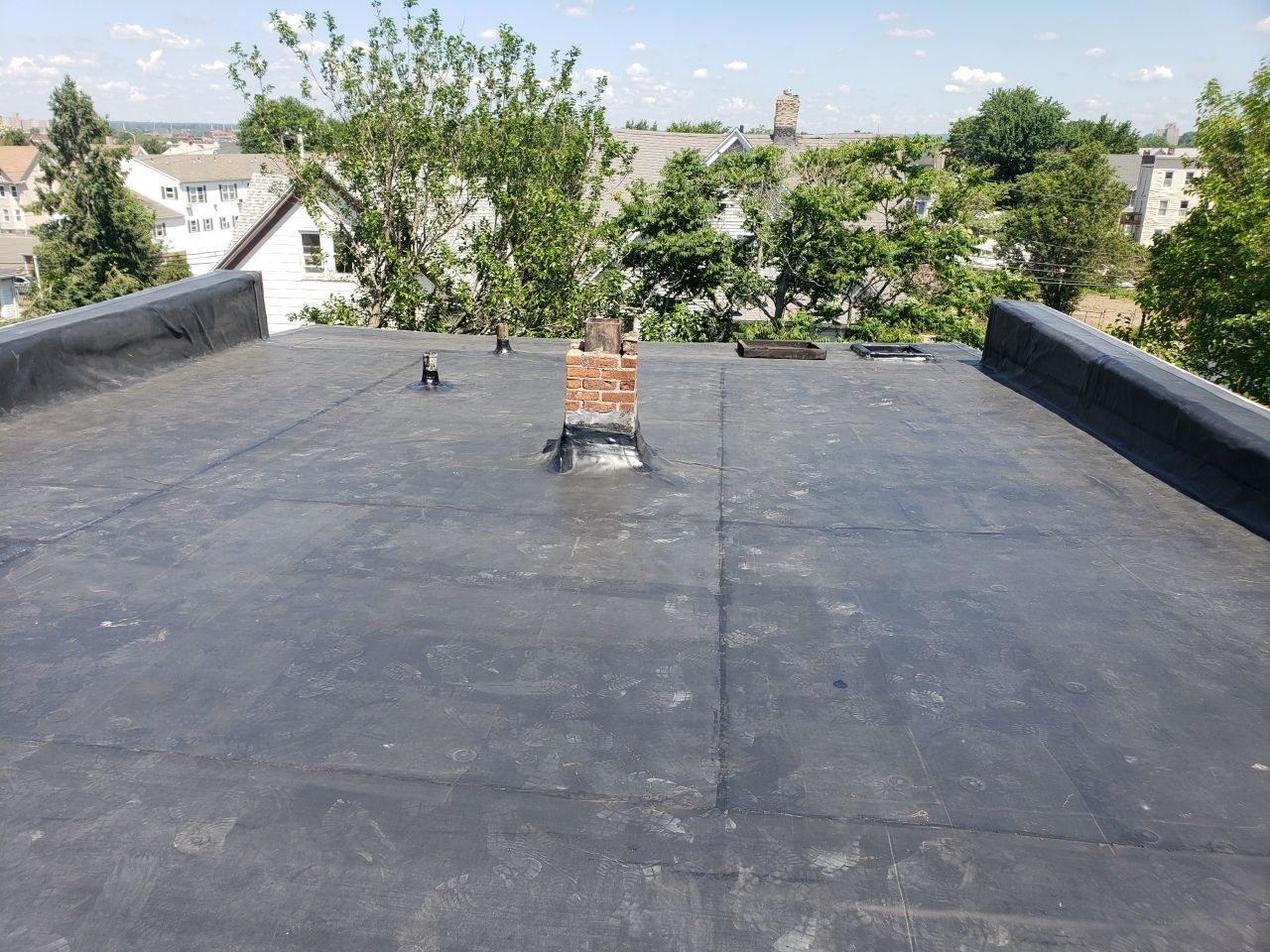 A black roof with a chimney on top of it