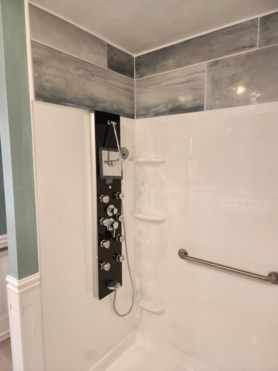 A bathroom with a shower and a hand rail.