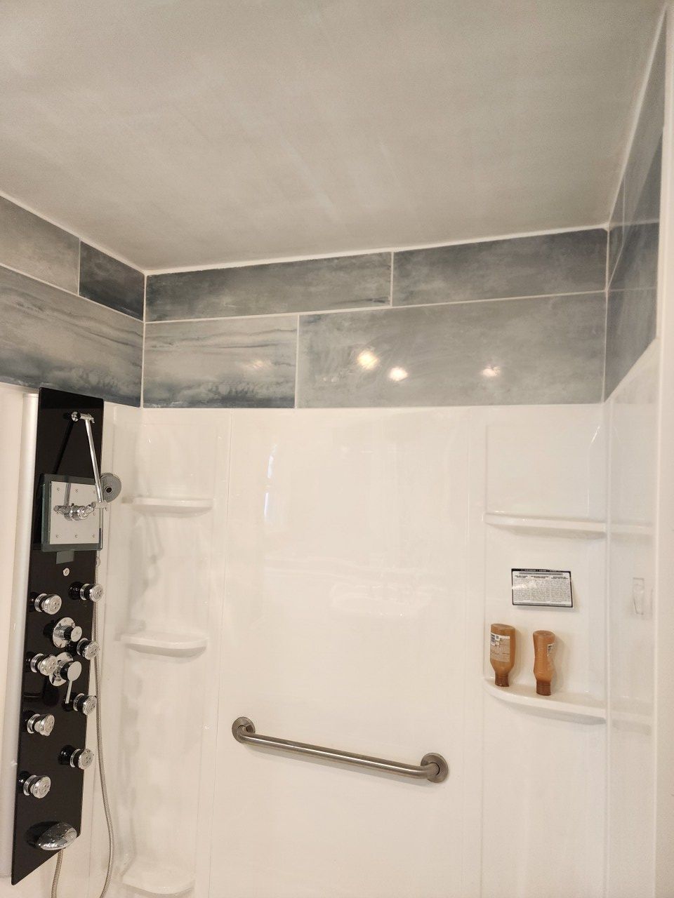 A bathroom with a shower and a hand rail.