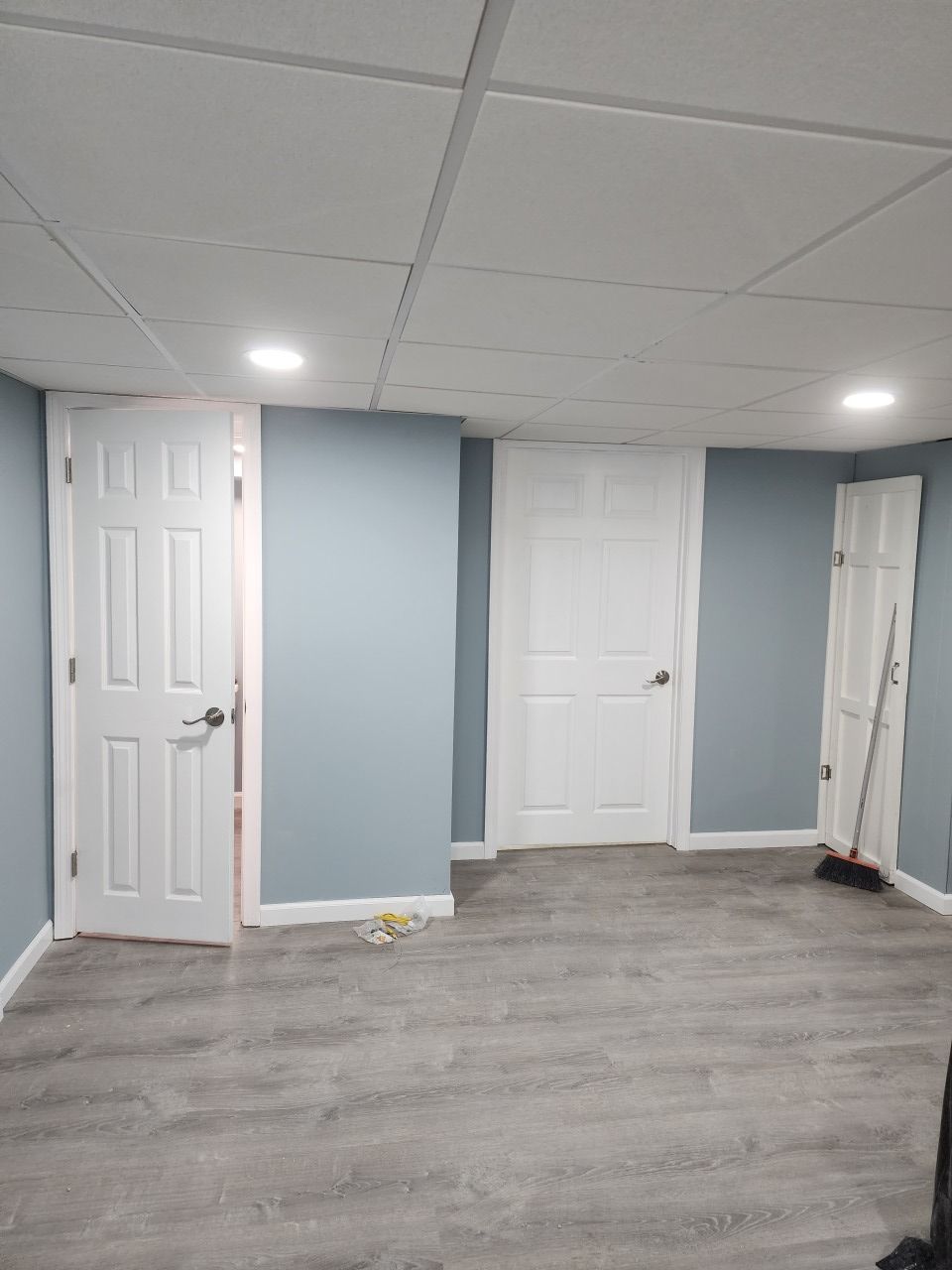 A basement with blue walls and white doors